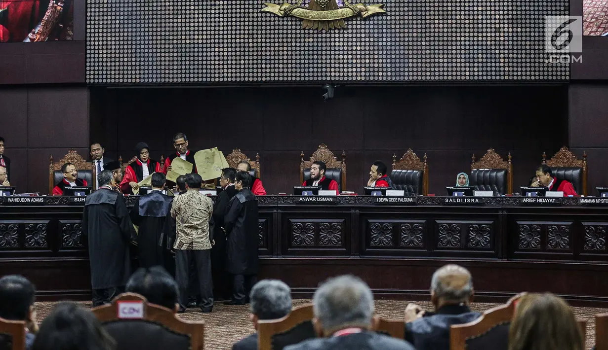 Majelis Hakim mengecek amplop yang dibawa Komisioner KPU, Hasyim Asyari selama sidang sengketa pilpres 2019 di Gedung MK, Jakarta, Kamis (20/6/2019). Kode tertentu menunjukkan bahwa amplop tersebut untuk menyimpan salinan form C1. (Liputan6.com/Faizal Fanani)