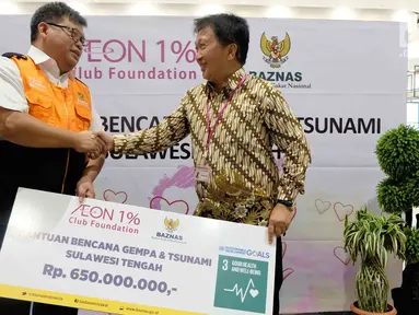 Deputy General Manager PT AEON Indonesia Eddy Effendy Irawan (kanan) secara simbolis menyerahkan donasi senilai 5 juta yen atau sekitar Rp 650 juta kepada Dirut BAZNAS Arifin Purwakananta (kiri) di Jakarta, Jumat (12/10). (Liputan6.com/HO/Arif)