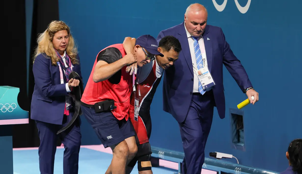 Lifter Indonesia, Eko Yuli Irawan dipapah keluar arena oleh ofisial setelah gagal melakukan angkatan clean and jerk pada cabang olahraga angkat besi 61 kg putra Olimpiade 2024 di South Paris Arena, Paris, Prancis, Rabu (07/08/2024). (Dok. NOC Indonesia/Naif Muhammad Al'as)