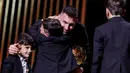 Pemain Inter Miami, Lionel Messi, dipeluk anaknya saat menerima penghargaan Ballon d'Or di Theatre du Chatelet, Paris, Selasa (31/10/2023). La Pulga berhasil menyabet penghargaan Ballon d'Or 2023 atau yang kedelapan sepanjang kariernya. (AFP/Franck Fife)