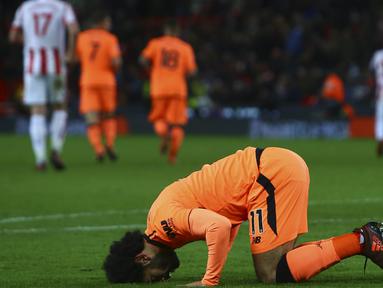 Gelandang Liverpool, Mohamed Salah, sujud merayakan gol yang dicetaknya ke gawang Stoke pada laga Premier League di Stadion Bet365, Stoke-on-Trent, Rabu (29/11/2017). Stoke kalah 0-3 dari Liverpool. (AFP/Geoff Caddick)