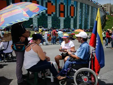 Demonstran anti-pemerintah memainkan kartu di jalan raya saat unjuk rasa melawan Presiden Nicolas Maduro, di Caracas, Venezuela, (15/5). Para demonstran menuntut Presiden Nicolas Maduro mundur dari jabatannya. (AP Photo / Ariana Cubillos)