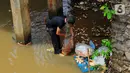 Warga kerja bakti membersihkan sampah yang terbawa aliran Kali Baru di bawah Jembatan Merah, Jalan Pitara Raya, Depok, Jawa Barat, Rabu (19/2/2020). Pascahujan deras yang terjadi sehari sebelumnya, sampah dari arah Bogor terbawa aliran Kali Baru hingga ke Depok. (merdeka.com/Magang/Muhammad Fayyadh)