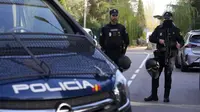 Polisi berjaga-jaga ketika petugas lain dengan rompi kuning berjalan kembali di area yang ditutup di sebelah kedutaan Ukraina di Madrid, Spanyol, Rabu, 30 November 2022. (Paul White/AP)