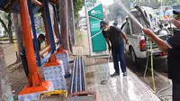Petugas membersihkan fasilitas halte yang terletak di kawasan Tangerang, Senin (15/6/2020). Jelang penerapan tatanan kenormalan baru atau new normal, prasarana transportasi umum, seperti halte bus dipersiapkan agar bisa menjalankan protokol kesehatan dengan baik. (Liputan6.com/Angga Yuniar)