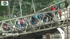 Truk sarat muatan material bangunan ini pun terguling setelah tiang penyanggah jembatan roboh akibat tidak kuat menahan beban di atasnya.