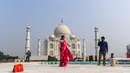 Turis mengunjungi Taj Mahal di Agra, India pada Senin (21/9/2020). Taj Mahal kembali dibuka untuk umum hari ini, Senin (21/9), dalam gerakan simbolis seperti biasa, bahkan ketika India tampaknya akan mengambil alih AS sebagai pemimpin global dalam infeksi Virus Corona COVID-19. (Sajjad HUSSAIN/AFP)