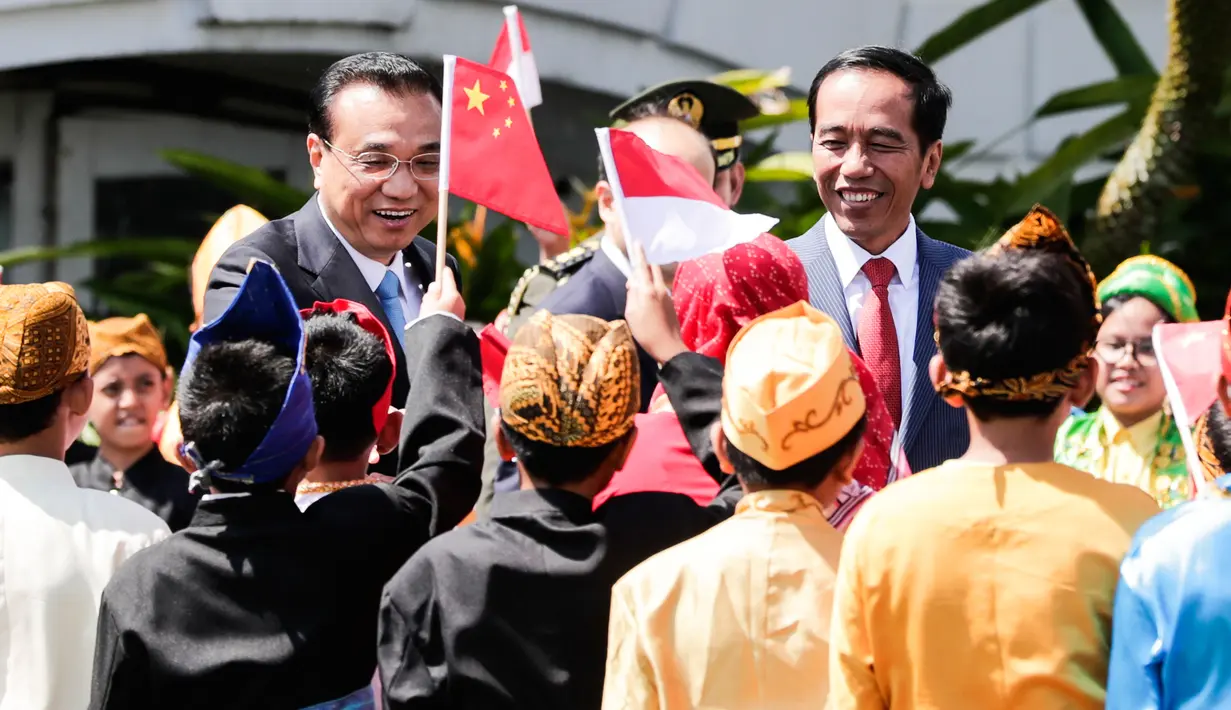 Presiden Jokowi bersama PM China Li Keqiang menyapa anak-anak berbaju daerah saat penyambutan kenegaraan di Istana Bogor, Senin (7/5). Kerja sama perdagangan dan investasi merupakan isu utama yang akan dibahas Li dan Jokowi. (Mast Irham/Pool via AP)