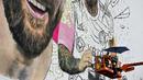 <p>Seniman Argentina, Maximiliano Bagnasco sedang mengerjakan mural besar bergambar Lionel Messi di Wynwood, Miami, 10 Juli 2023. La Pulga akan melakukan debutnya di Inter Miami pada 21 Juli di Piala Liga. (AFP/Chandan Khanna)</p>