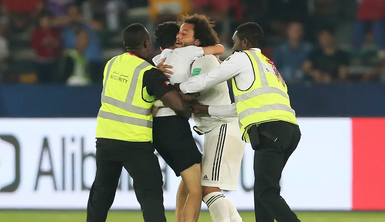 Seorang fans memeluk bek Real Madrid, Marcelo selama pertandingan semifinal Piala Dunia Antarklub 2018 antara Real Madrid melawan Kashima Antlers di stadion Zayed Sports City di Abu Dhabi, Uni Emirat Arab (19/12). (AP Photo/Kamran Jebreili)
