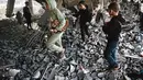 Anak-anak Palestina memeriksa puing-puing bangunan yang rusak milik Kementerian Wakaf Agama, yang digunakan sebagai tempat penampungan bagi pengungsi di kawasan Zeitoun, Kota Gaza, pada Kamis 20 November 2025, sehari setelah bangunan tersebut menjadi sasaran serangan militer Israel. Militer Israel kembali melancarkan rangkaian serangan ke sejumlah wilayah Gaza pada Rabu (19/11/2025). (Omar AL-QATTAA/AFP)