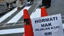 Kurangnya perhatian akan hak para pejalan kaki membuat para relawan ini untuk membuat jalur zebra cross di depan Stasiun Sudirman, Jakarta, Jumat (13/3/2015). (Liputan6.com/Faizal Fanani)