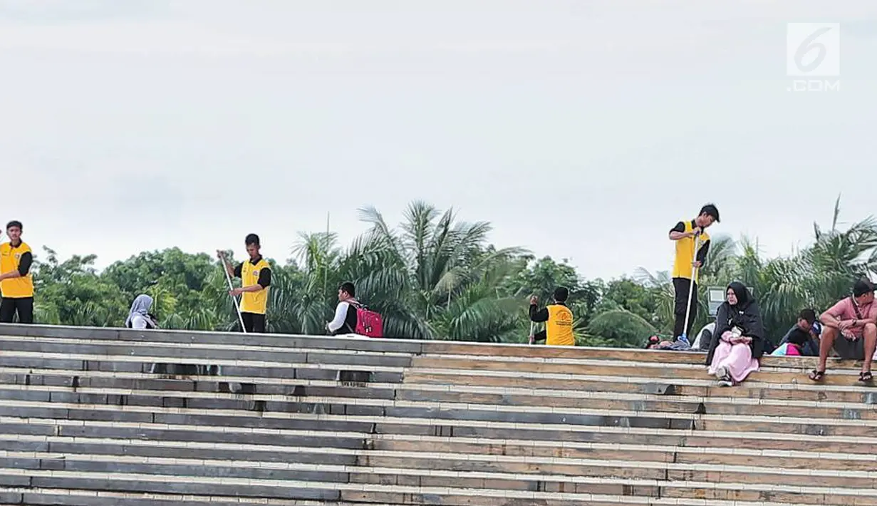 Petugas kebersihan membersihkan sisa sampah usai perayaan Tahun Baru 2019 di Monas, Jakarta, Selasa (1/1). Pemprov DKI Jakarta mengimbau perayaan tahun baru secara sederhana mengingat bencana yang terjadi di beberapa daerah. (Liputan6.com/Faizal Fanani)