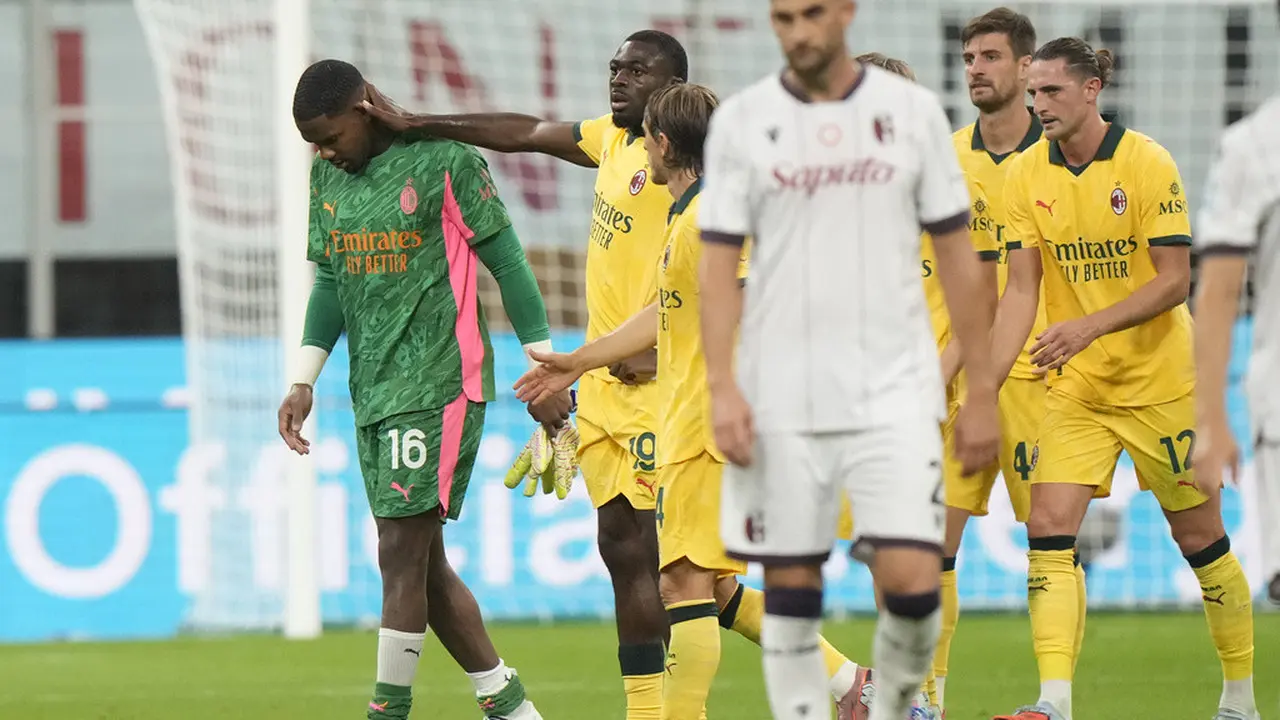 Ekspresi sedih Mike Maignan saat harus keluar lapangan di laga AC Milan vs Bologna di San Siro, Senin (15/09/2025). (AP Photo/Luca Bruno)