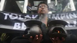 Aksi teatrikal aktivis dari Indonesia Corruption Watch (ICW) untuk menolak kehadiran pimpinan KPK bermasalah di depan Gedung Merah Putih KPK, Jakarta, Jumat (20/12/2019). Aksi penolakan digambarkan dengan keberadaan dua dukun yang tengah mengusir roh jahat. (merdeka.com/Dwi Narwoko)