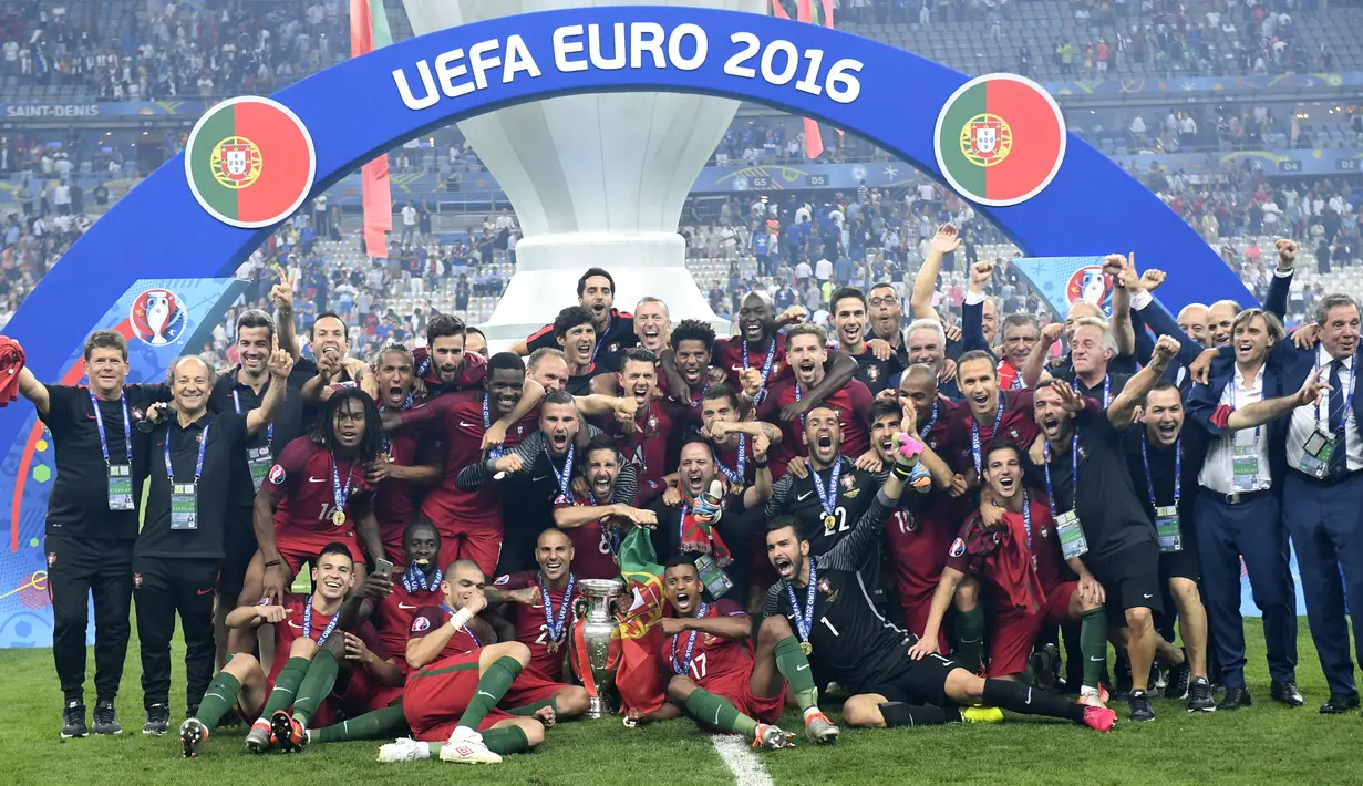 Para pemain Portugal berpose dengan trofi Piala Eropa 2016 usai mengalahkan Prancis pada laga final di Stade de France, Saint-Denis, Prancis, 10 Juli 2016. Piala Eropa 2020 rencananya dimulai pada 11 Juni hingga 11 Juli 2021. (PHILIPPE DESMAZES/AFP)