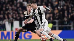 Aksi Federico Bernadeschi berusaha melewati pengawasan Frankie De Jong pada leg kedua laga perempat final Liga Champions yang berlangsung di Stadon Allianz, Turin, Rabu (17/4). Juventus kalah 1-2 Kontra Ajax. (AFP/Filippo Monteforte)