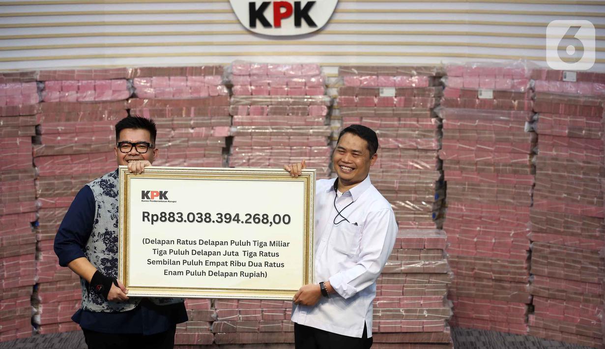 Penyerahan uang dilakukan secara simbolis ditandai dengan surat berita acara serta plakat uang bertuliskan Rp 883.038.394.268 dari Plt Deputi Penindakan dan Eksekusi KPK Asep Guntur Rahayu kepada Direktur Utama PT Taspen, Rony Hanityo Aprianto. Tampak dalam foto, Plt Deputi Penindakan dan Eksekusi KPK, Asep Guntur Rahayu (kanan) menyerahkan secara simbolis uang sebesar Rp 300 miliar dari Rp 883 miliar kepada Direktur Utama PT TASPEN (Persero), Rony Hanityo Aprianto, di gedung Merah Putih Komisi Pemberantasan Korupsi (KPK), Jakarta, Kamis (20/11/2025). (Liputan6.com/Helmi Fithriansyah)