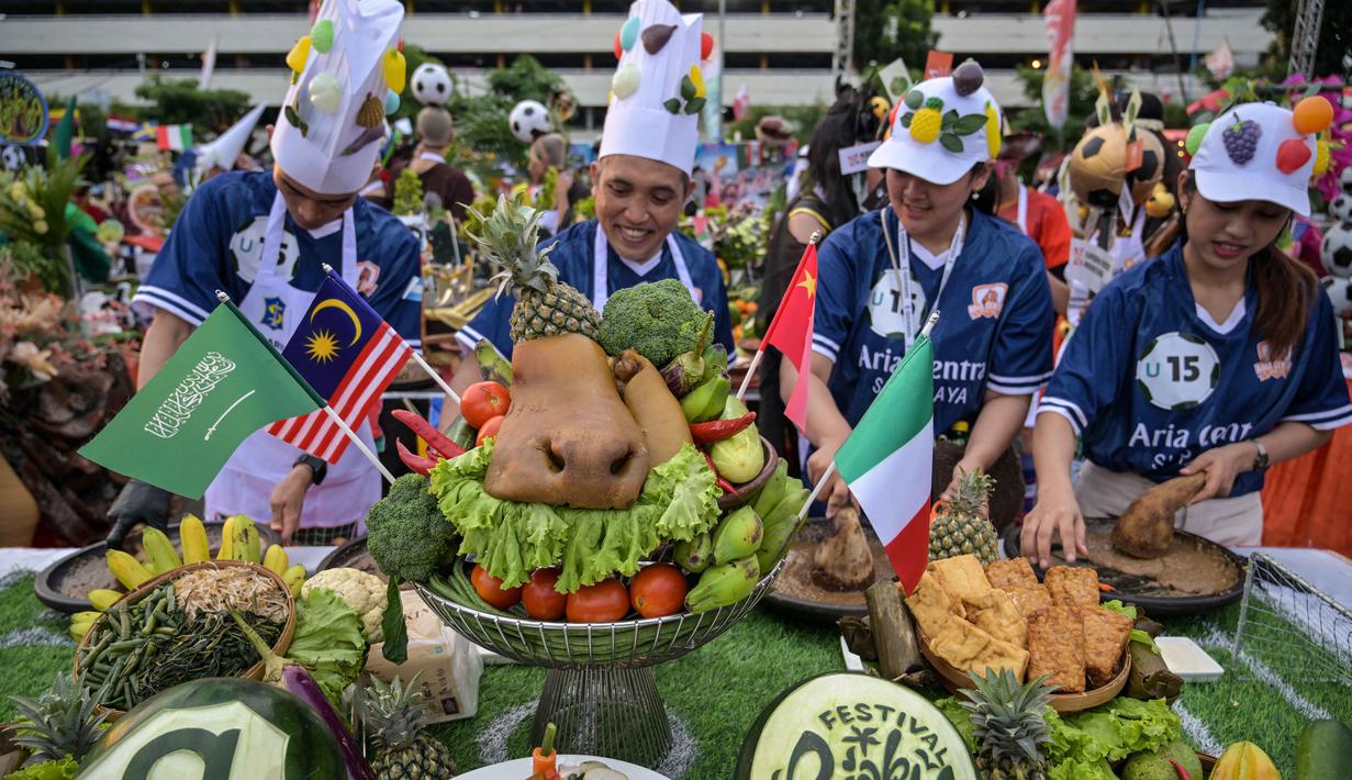 Berbagai peserta tampil kreatif dengan memadukan unsur olahraga sepak bola internasional bersama kekayaan kuliner khas Surabaya. Tampak dalam foto, para peserta yang mengenakan seragam tim sepak bola menyiapkan rujak uleg, salad gurih tradisional Indonesia yang berisi moncong sapi dan sayuran, dalam Festival Rujak Uleg 2026 di Surabaya, Jawa Timur, Sabtu 9 Mei 2026. (JUNI KRISWANTO/AFP)