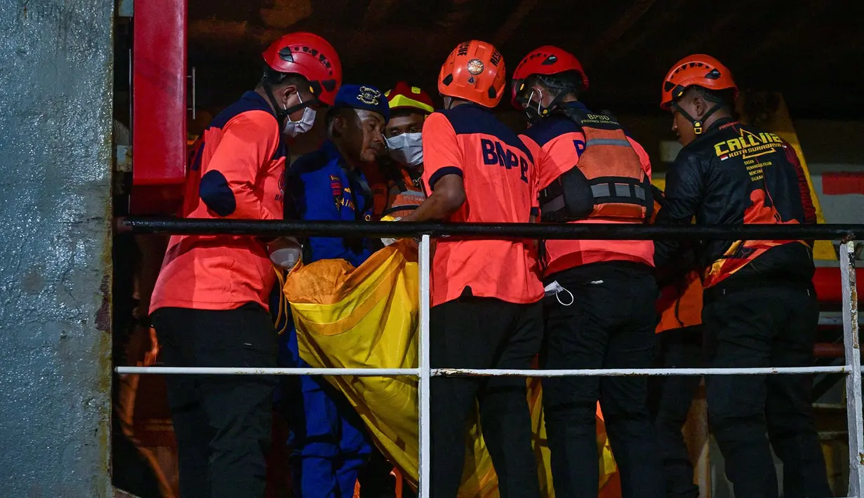 Sejumlah petugas mengangkat kantong berisi jenazah korban kebakaran KM Mutiara Sentosa II setibanya di Dermaga Jamrud Utara, Pelabuhan Tanjung Perak, Surabaya, Jawa Timur, Senin (3/8/2026).  (AFP/ Juni Kriswanto)