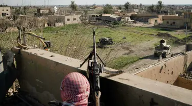 Anggota Syrian Democratic Forces (SDF) mengintai militan ISIS dari sebuah bangunan di kantong terakhir kekhalifahan di Baghouz, Suriah, Senin (18/2). ISIS dilaporkan kian terkepung. (AP Photo/Felipe Dana)