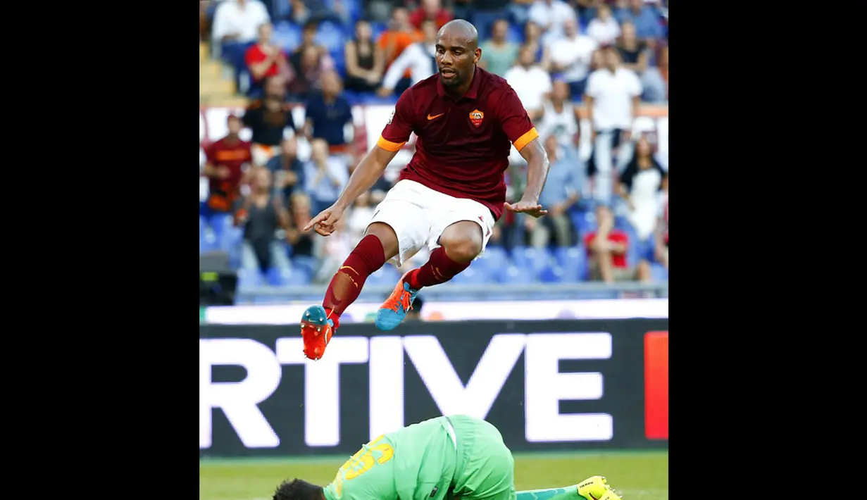 Pemain belakang AS Roma, Maicon (atas), melompat menghindari penjaga gawang Hellas Verona, Pierluigi Gollini, saat berlaga dilanjutan Serie A Italia di Stadion Olimpiade, Roma (27/9/2014). AS Roma unggul dua gol atas Hellas Verona. (REUTERS/Tony Gentile)