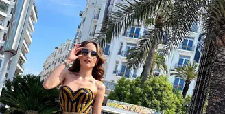 Berzodiak Leo, Cinta Laura kerap tampil fashionable dengan paduan bustier yang apik. Salah satunya saat memadukan bustier beraksen lurik dengan celana palazo keemasan. [@claurakiehl]