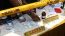 Petugas menunjukkan barang bukti pil ekstasi saat rilis di sebuah perumahan di Pondok Rajeg, Cibinong, Senin (24/9). Polisi menyita sejumlah barang bukti diantaranya 158 gram sabu, 3000 pil ekstasi dan satu paket ganja. (Liputan6.com/Helmi Fithriansyah)