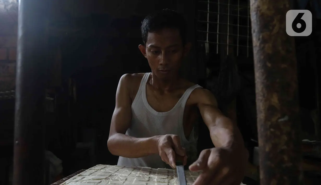 Pengrajin memotong tahu di pabrik kawasan Duren Tiga, Jakarta Selatan, Rabu (7/12/2022). Para pengrajin tahu di Duren Tiga itu juga mengatakan bahwa pabrik sempat mogok membuat tahu selama dua hari sebagai unjuk rasa atas harga kedelai yang naik. (Liputan6.com/Herman Zakharia)