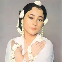 Suzzanna&nbsp; dikenal memiliki ciri khas mengenakan melati, seperti foto ini memadukan kebaya putih dengan aksesori melati di lengan dan sanggul rambutnya.&nbsp;[@suzzannaofficial]