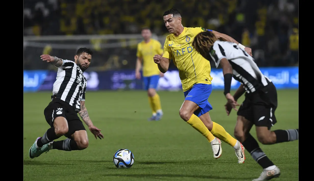 Pemain Al Nassr, Cristiano Ronaldo (tengah), berusaha mengontrol bola dibayangi dua pemain Al Shabab, Ever Banega (kiri) dan Fawaz Al-Sagour, dalam laga perempat final King's Cup Arab Saudi 2023 yang digelar di Al Shabab Club Stadium, Selasa (12/12/2023) dini hari WIB. (AFP/Str)
