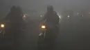 Kendaraan melaju dengan menyalakan lampu depan saat kabut tebal menyelimuti Lahore, Pakistan, 15 Desember 2021. Kabut tebal membuat kendaraan harus melaju lambat karena jarak pandang berkurang. (AP Photo/K.M. Chaudary)