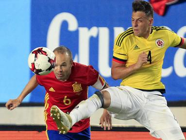 Pemain Spanyol, Andres Iniesta (kiri) berduel dengan pemain Kolombia, Santiago Arias pada Laga Persahabatan di Estadio Nueva Condomina, Murcia, Spanyol (7/6/2017). (AP/Alberto Saiz)