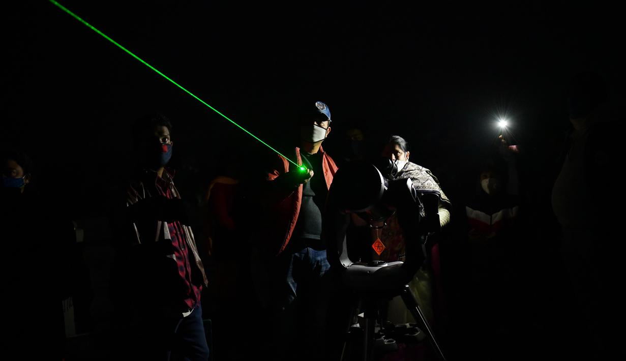 Orang-orang mengantre menyaksikan fenomena "konjungsi besar" planet Jupiter dan Saturnus di Udaipur, 50 kilometer dari Agartala,  India (22/12/2020). Konjungsi tahun 2020 sangat jarang terjadi dan planet-planet belum pernah terlihat sedekat ini pada malam hari sejak abad pertengahan, pada tahun 1226