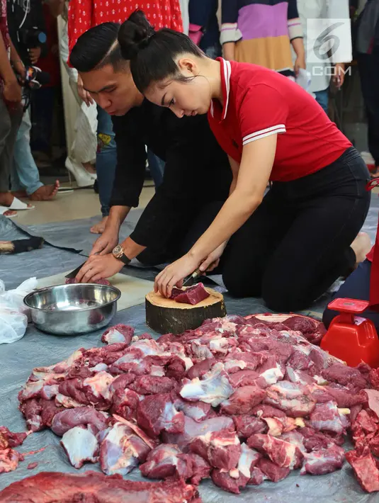 Aktris Nikity Willy didampingi kekasihnya, Indra Priawan Djokosoetono memotong daging kurban Idul Adha untuk dibagi bagikan di kediamannya Jatiwaringin, Jakarta (1/9). (Liputan6.com/Herman Zakharia)