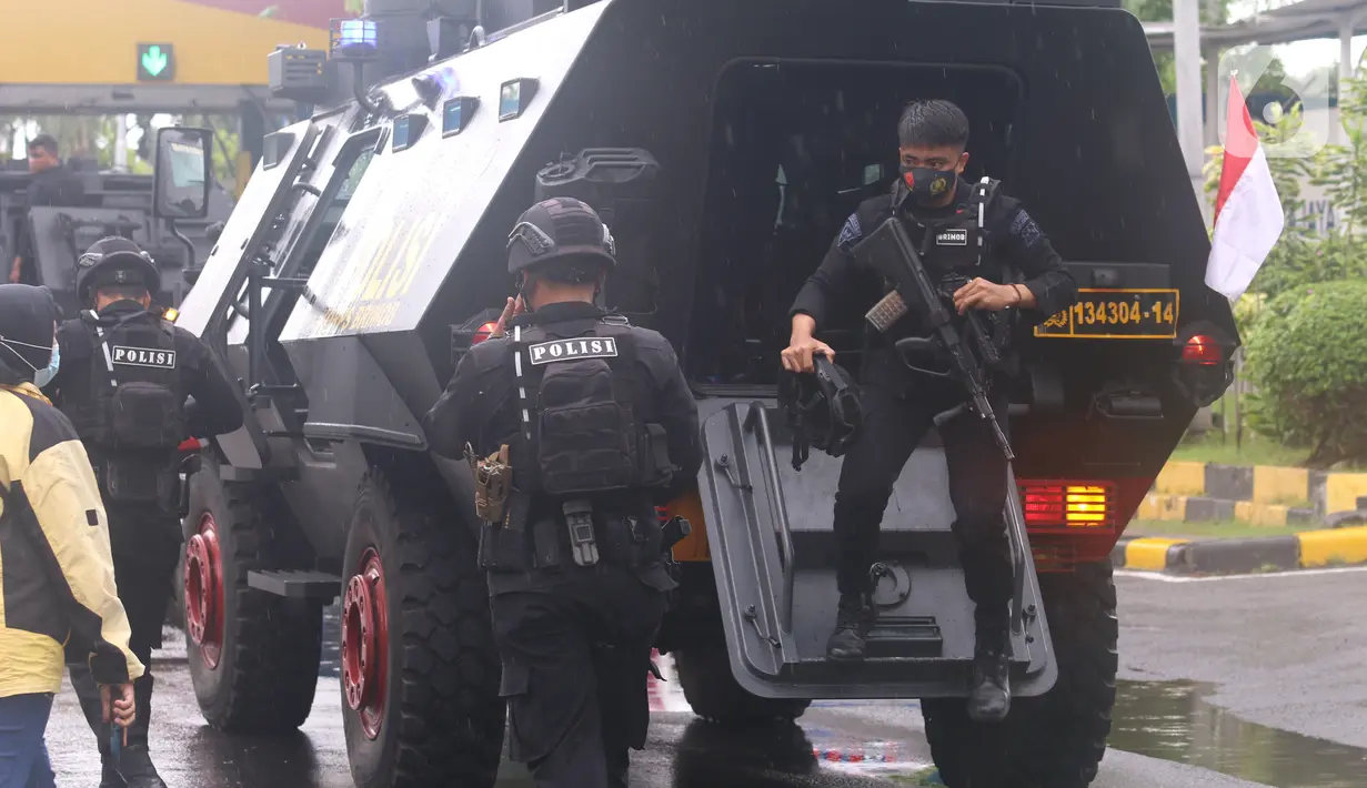 Polisi turun dari kendaraan taktis untuk penjemputan vaksin Covid-19 Sinovac di Terminal Kargo Bandara Soekarno-Hatta, Tangerang, Kamis (31/12/2020). TNI dan Polri diterjunkan untuk mengawal kedatangan vaksin Covid-19 dari Bandara Soetta menuju PT Bio Farma di Bandung. (Liputan6.com/Angga Yuniar)