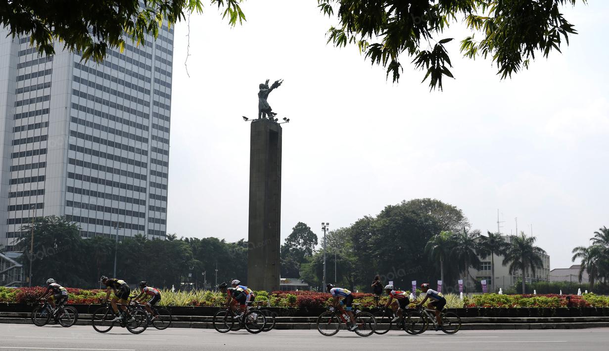 Para pebalap melewati patung Selamat Datang pada ajang Tour de Jakarta di Bundaran Hotel Indonesia, Jakarta, Sabtu (30/7/2016). (Bola.com/Nicklas Hanoatubun)