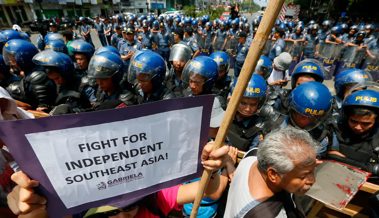 Polisi anti huru hara berjaga-jaga di depan Kedutaan Besar AS saat aksi protes berlangsung AS di Manila, Jumat (28/4). Demonstran mengecam imperealisme yang dilakukan oleh Amerika Serikat, Jepang dan China atas Asia Tenggara. (AP Photo / Bullit Marquez)