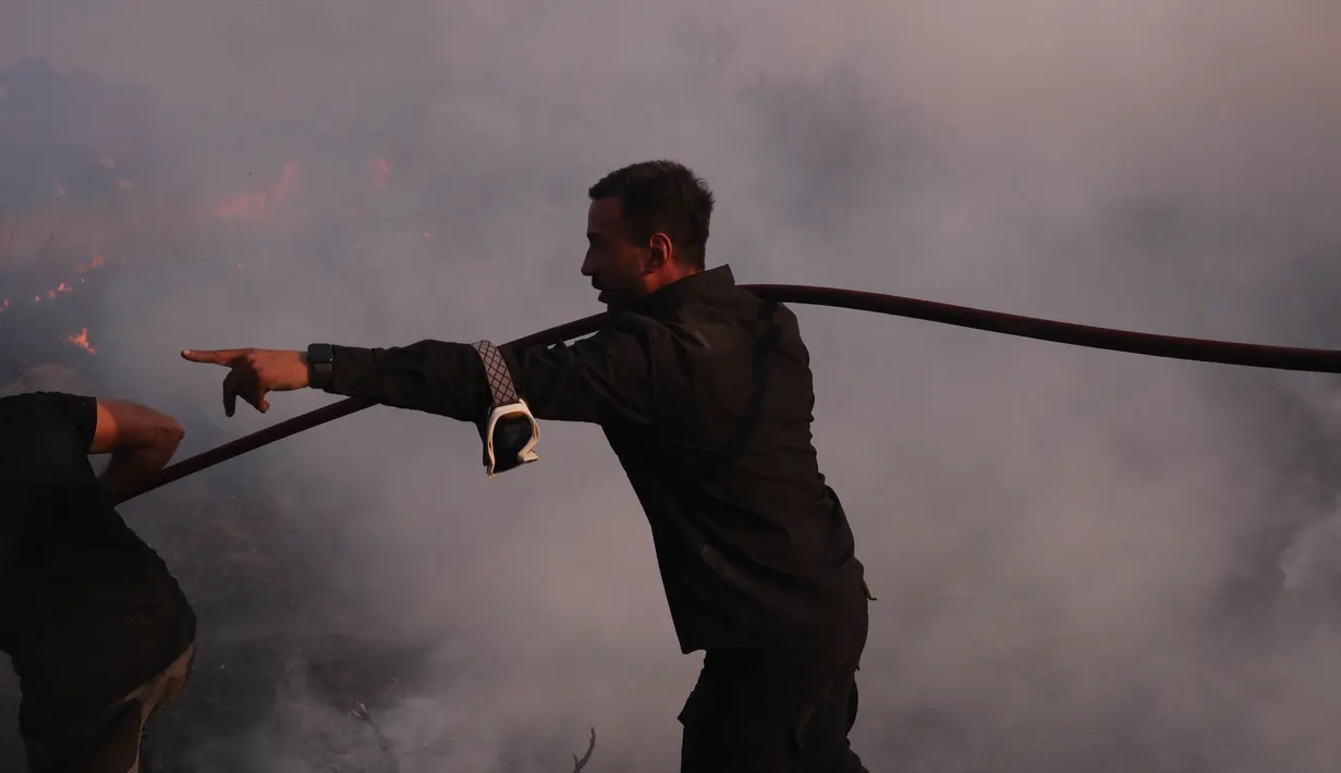 Lebih dari 670 petugas pemadam kebakaran dibantu oleh para sukarelawan terus berupaya memadamkan kebakaran hutan yang terjadi sejak Minggu (11/8/2024) waktu setempat. (AP Photo/Aggelos Barai)