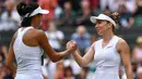 Petenis Rumania, Simona Halep berjabat tangan dengan petenis China, Shuai Zhang usai bertanding pada perempat final Grand Slam Wimbledon di London, Selasa (9/7/2019). Halep mengalahkan petenis non-unggulan asal China dengan memetik kemenangan 7-6, 6-1. (GLYN KIRK / AFP)
