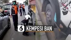 Terlihat seorang petugas Dishub didampingi rekannya sedang melakukan aksinya ngempesin dua ban depan truk.
