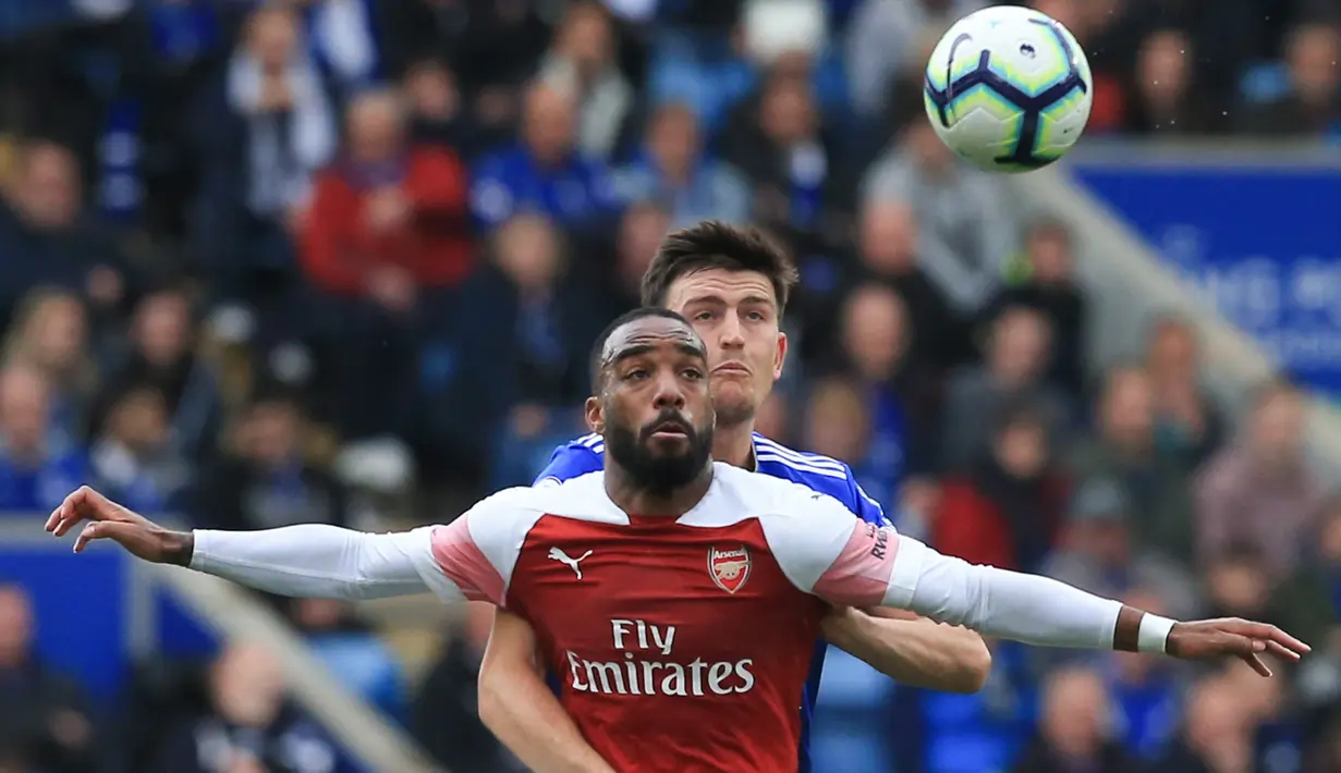 Bek Leicester City, Harry Maguire berebut bola dengan penyerang Arsenal, Alexandre Lacazette pada pertandingan Liga Inggris di King Power Stadium pada 28 April 2019. Harry Maguire pun kini berstatus bek termahal dunia. (AFP Photo/Lindsey Parnaby)