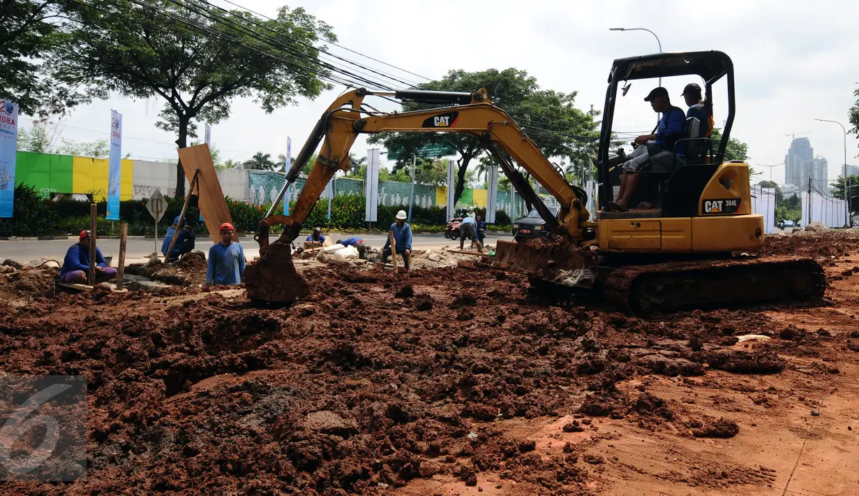 Sebuah alat berat diturunkan untuk mempercepat pengerjaan saluran air dan pedestrian di sekitar jalan Gerbang Pemuda, Jakarta, Senin (6/3). Pengerjaan ini terkait pelaksanaan Asian Games 2018 mendatang. (Liputan6.com/Helmi Fithriansyah)