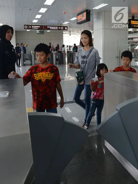 Warga mengetap kartu saat akan mengikuti uji coba kereta ringan atau light rail transit (LRT), Jakarta, Selasa (11/6/2019). Uji coba ini hanya akan melayani Stasiun Boulevard Utara, Stasiun Boulevard Selatan, Stasiun Pulo Mas, Stasiun Equestrian, dan Stasiun Velodrome. (merdeka.com/Imam Buhori)