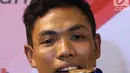 Pelari muda Indonesia, Lalu Muhammad Zohri menggigit medali emas saat upacara penyambutan di Terminal 3 Bandara Soetta, Tangerang, Selasa (17/7/2018). Lalu M Zohri meraih emas lari 100m putra di Kejuaraan Dunia Atletik U-20. (Liputan6.com/Helmi Fithriansyah)