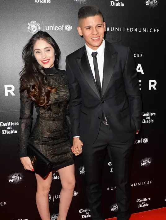  Bek Manchester United, Marcos Rojo (kanan) dan pacarnya Eugenia Lusardo berpose di atas karpet merah saat tiba untuk menghadiri "Inggris untuk UNICEF Gala Dinner" di Old Trafford, Manchester, Inggris, (29/11). (AFP PHOTO/OLI SCARFF)