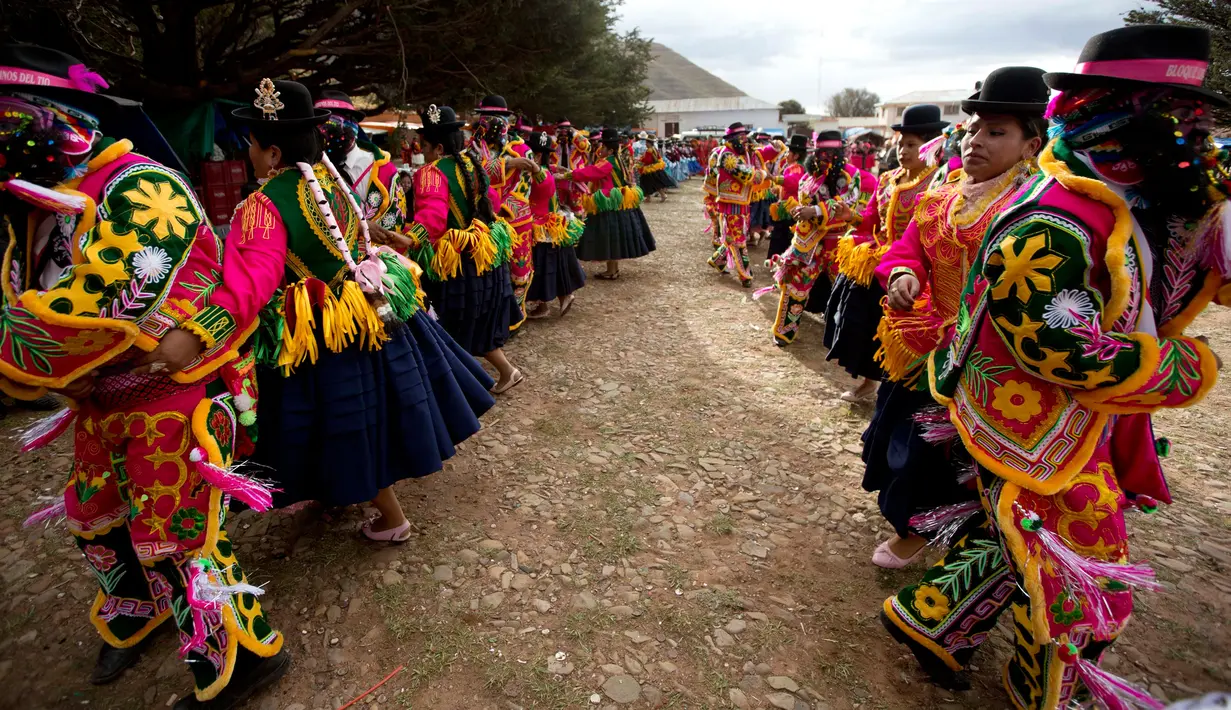 Sejumlah warga berpasang-pasangan menari saat karnaval Anata Andina (Andean karnaval) di Caquiaviri, Bolivia, Selasa (17/1). Karnaval tersebut dimeriahkan dengan penampilan musik seperti orkestra dan band. (AP Photo/Juan Karita)