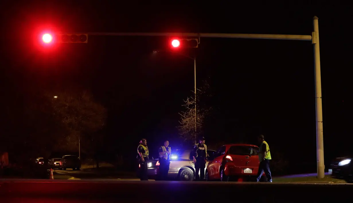Petugas memblokir jalan di dekat area ledakan  di Austin, Texas (18/3). Belum ada orang yang ditangkap terkait rentetan serangan bom ini. Polisi dan FBI bahkan belum bisa mengendus jejak para pelaku. (AP Photo/Eric Gay)