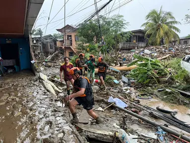 Tim penyelamat mengevakuasi seorang wanita setelah Badai Tropis Penha melanda daerah di Iligan, provinsi Lanao del Norte, Filipina, pada Jumat 6 Februari 2026. Sedikitnya empat orang tewas dan lebih dari 6.000 orang mengungsi imbas terjangan badai tropis Penha yang memicu banjir serta tanah longsor di Filipina selatan pada Jumat 6 Februari 2026. (Merlyn Manos/AFP)