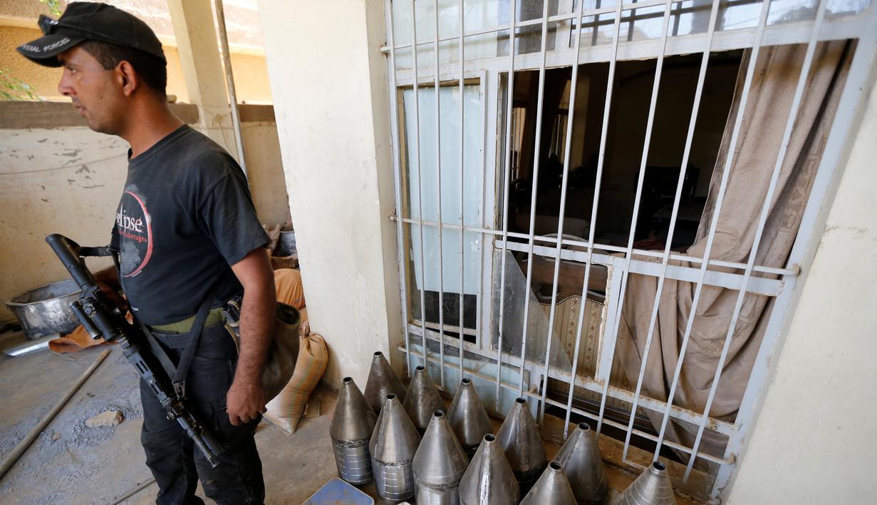 Seorang anggota pasukan kontraterorisme Irak berjaga di bangunan yang digunakan sebagai pabrik senjata militan ISIS yang berhasil ditemukan di Fallujah, Irak, Kamis (23/6). (REUTERS/Thaier Al-Sudani)